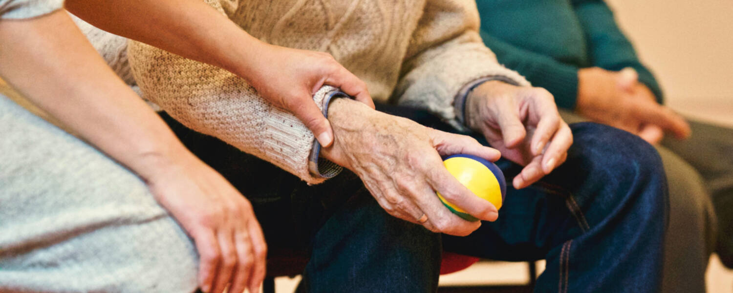 Person holding a stress ball seated in between two people