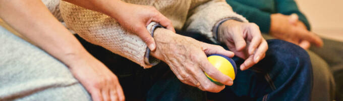 Person holding a stress ball seated in between two people