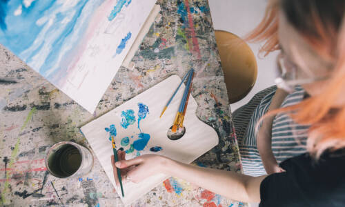 Salem College student taking paint from a palette