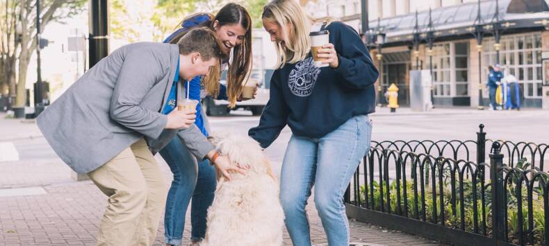 Salem College students petting a dog