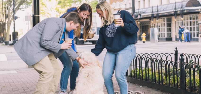 Salem College students petting a dog