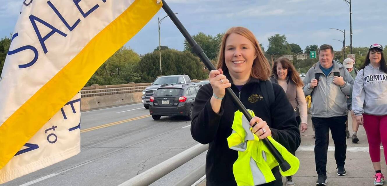 President Summer McGee holding the Journey to Salem flag while walking