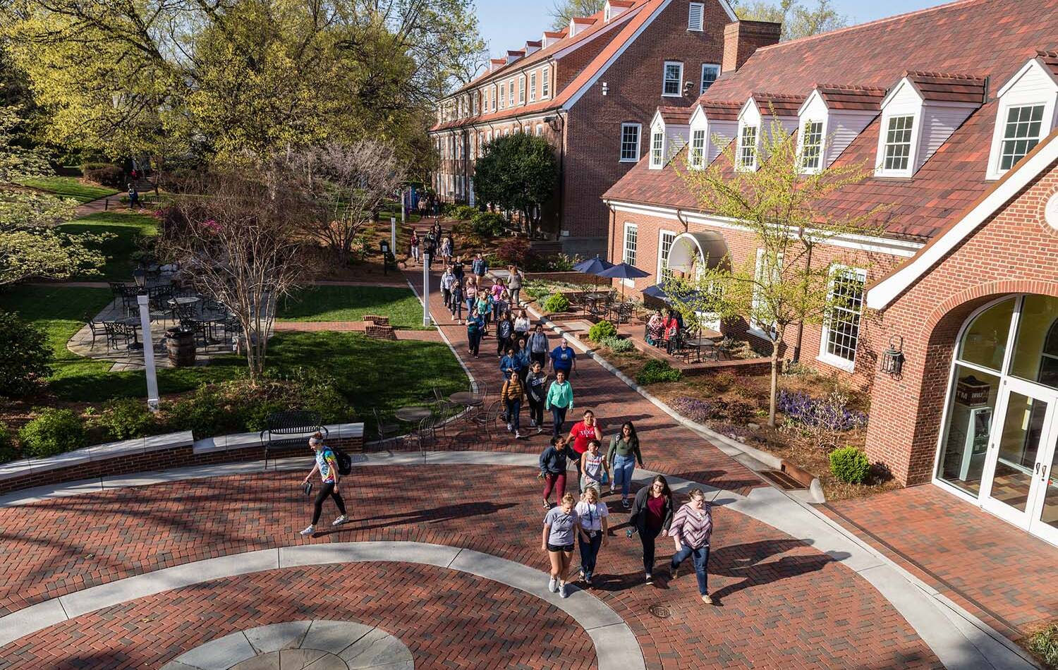 Salem College students walking on campus in front of student life building