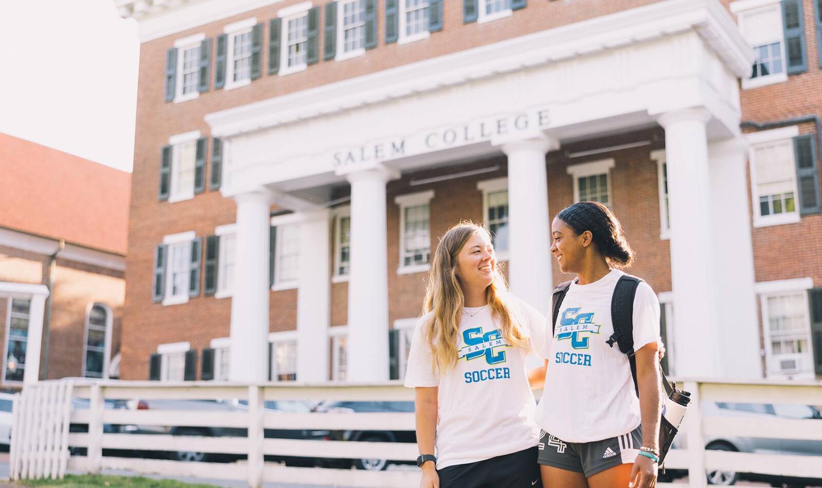 Two students in front of campus building at Salem College