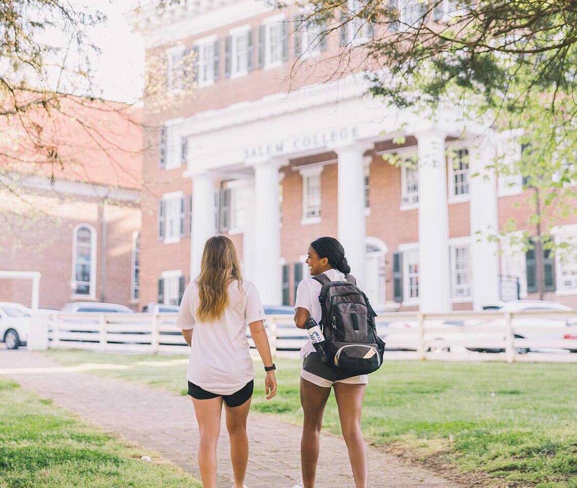 Two Salem College students on campus in front of Main Hall
