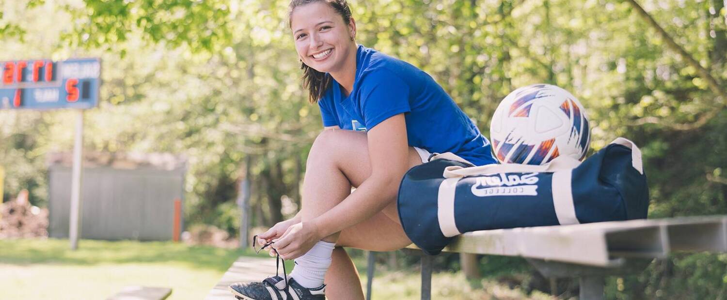 Salem College soccer athlete tying her shoe