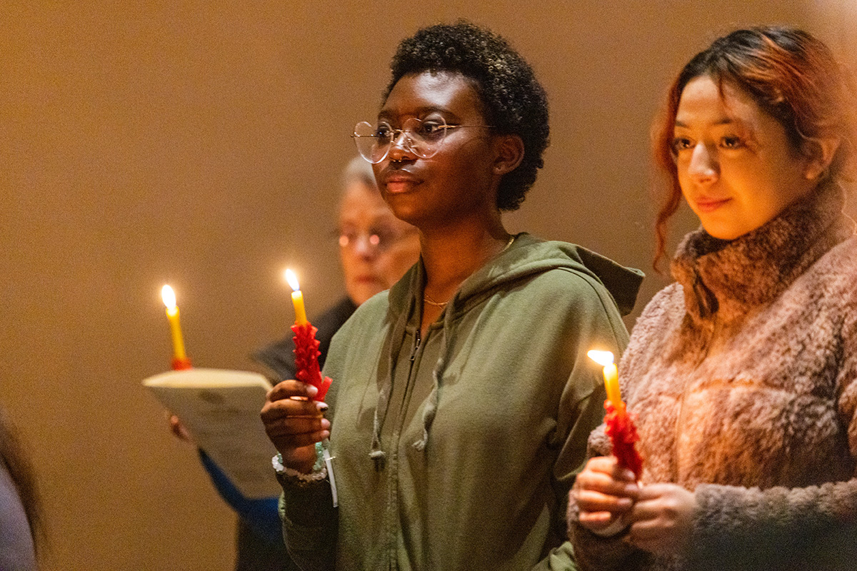 Two students holding candles at candle ceremony