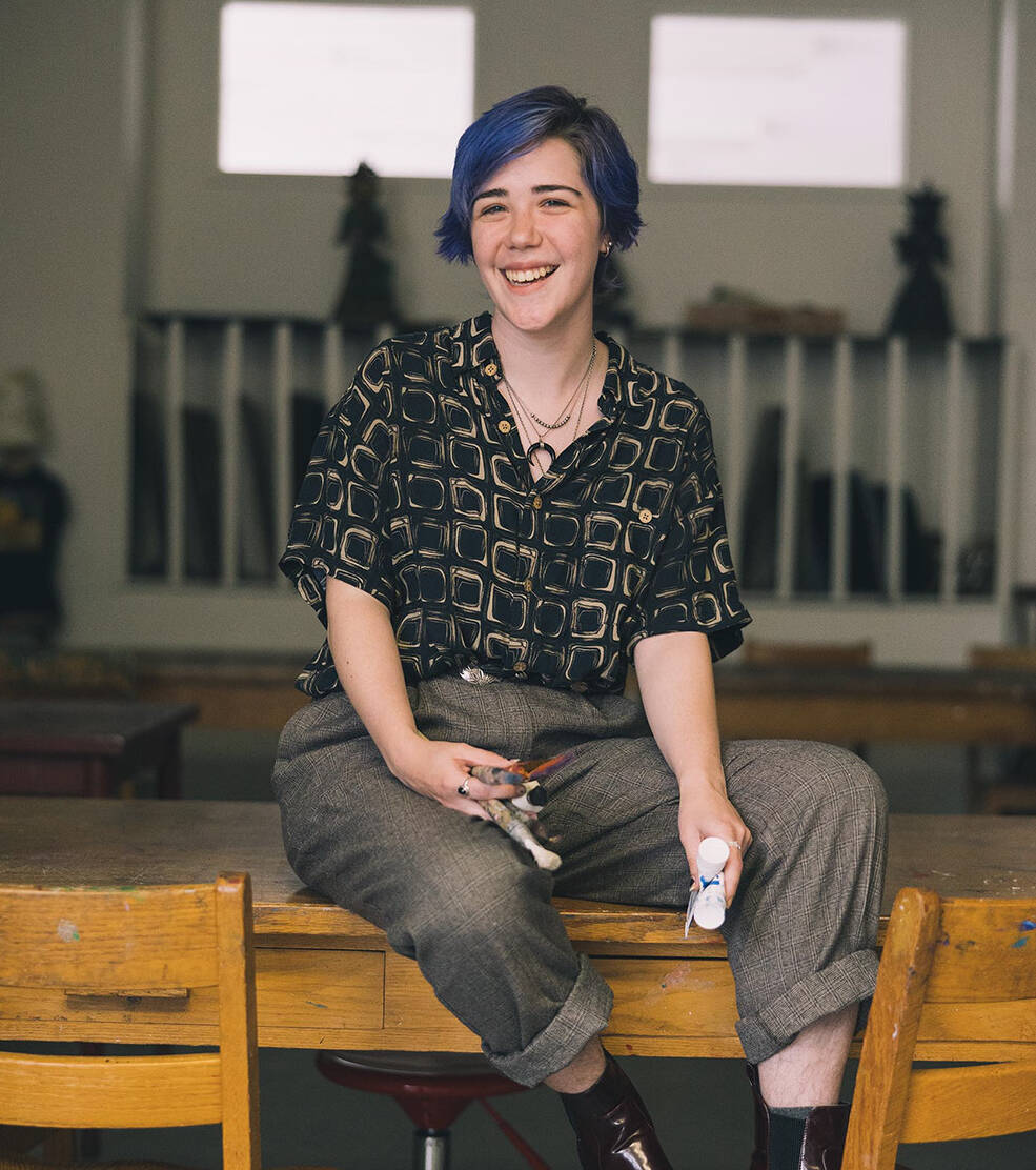 Salem College student holding paintbrush