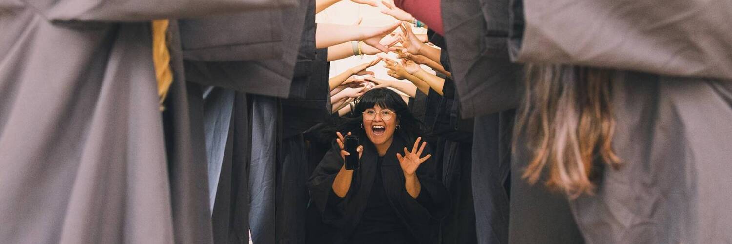 Salem College graduate walking through tunnel made by students arms