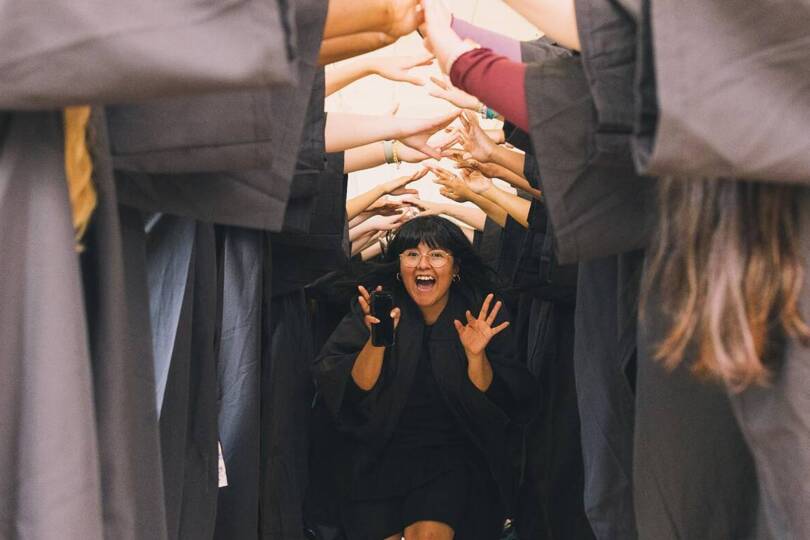 Salem College graduate walking through tunnel made by students arms