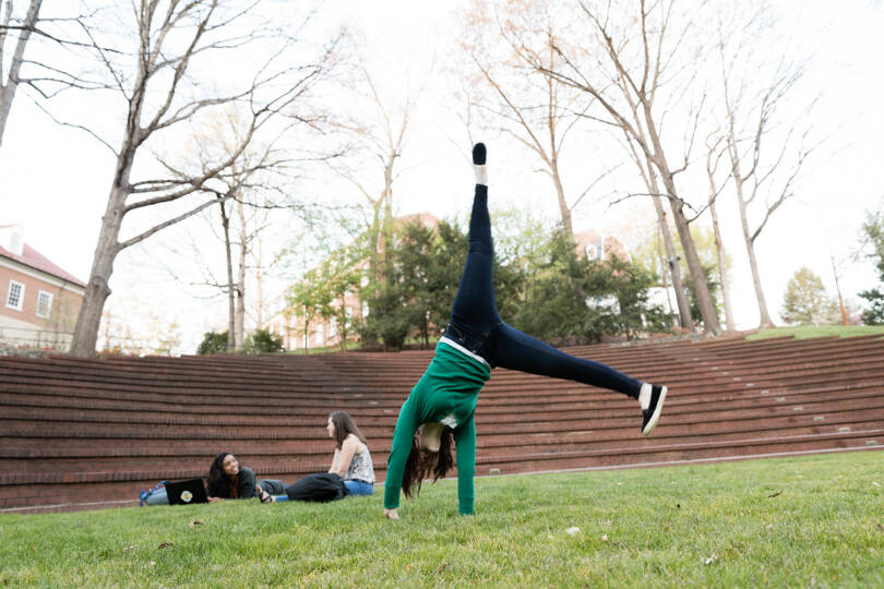 Student doing a cartwheel at the May Dell on the Salem College campus